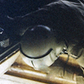 28 October 1969: A crewman scans for enemy activity through a 'spotter' hole in the floor of the helicopter en route to Fire Support Base Discovery. Interior of helicopter with man in helmet looking out of hole in the floor