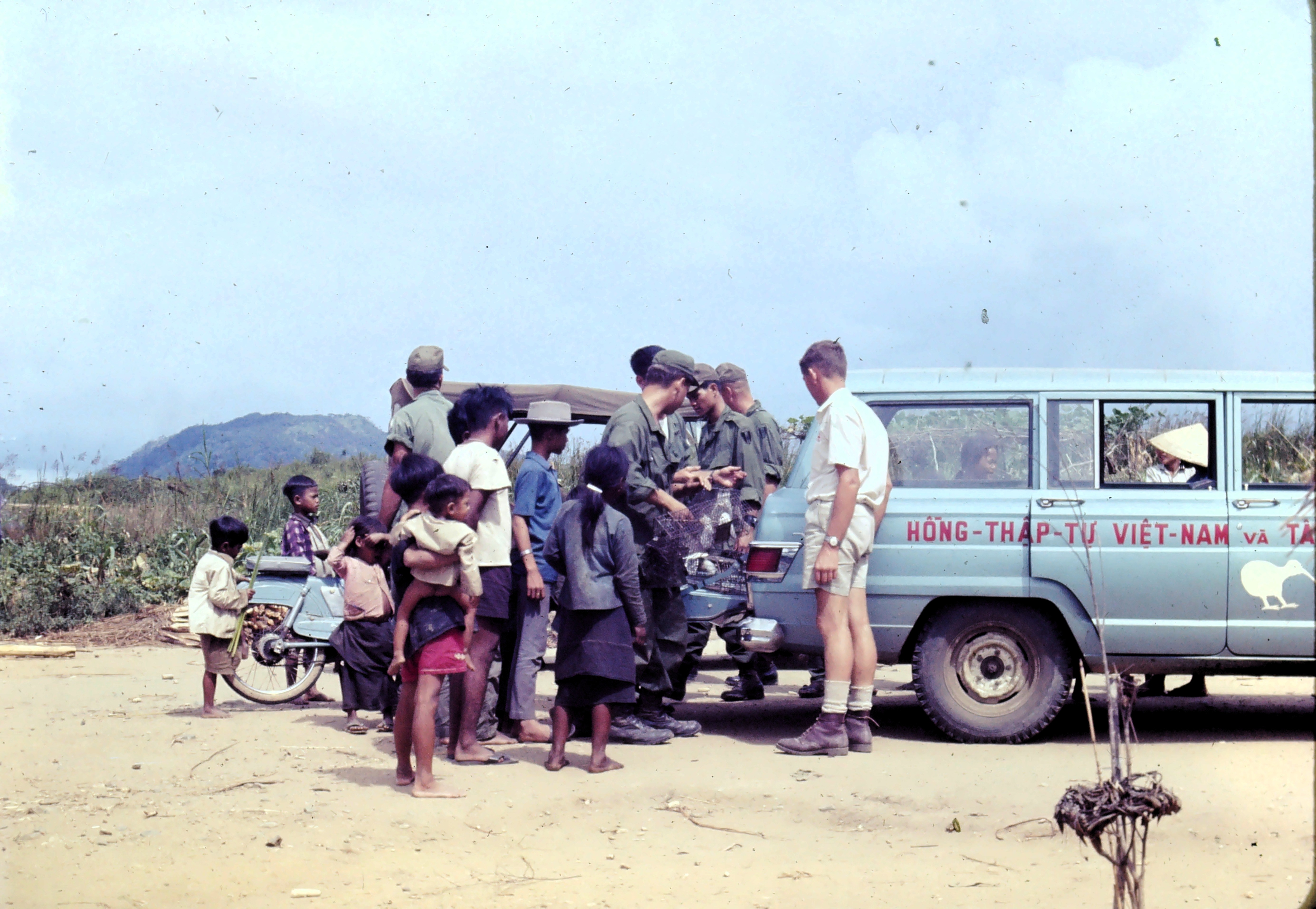 People gathered watching wire traps being loaded into the back of a Red Cross vehicle