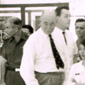 Malcolm Knox Black and white photograph of people, some in military and medical uniforms, standing next beds with patients lying in them.