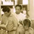 Malcolm Knox Three men reading books in a room filled with medical supplies.