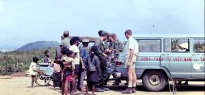 People gathered watching wire traps being loaded into the back of a Red Cross vehicle