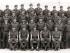 Group of men in military uniform sitting and standing in rows.