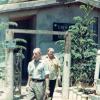 Colour photograph of two men leaving a building