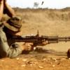 Soldier being shown how to use a machine gun