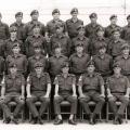 Group of men in military uniform sitting and standing in rows.