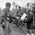 Brian Wilson checks a Vietnamese civilian's identification card, 1967