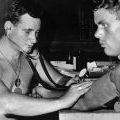 Sgt Joe Tate carries out a routine medical on a New Zealand gunner at Nui Dat, 1966.