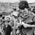 European woman in military uniform surrounded by Asian children